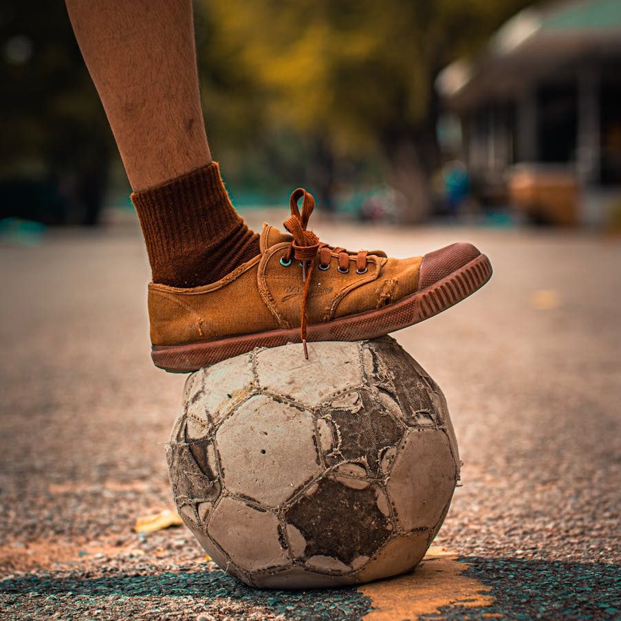 person stepping on a soccer ball